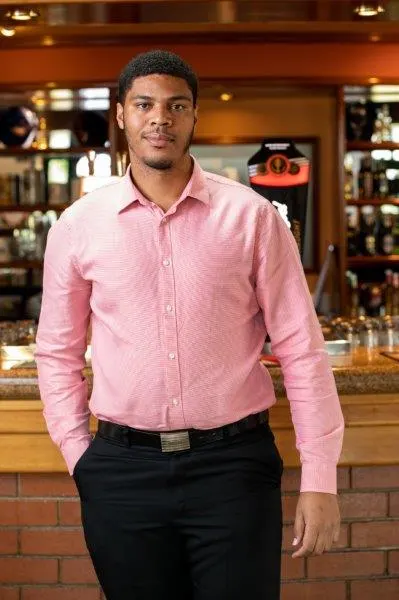 Neil Samson in a pink shirt, smiling